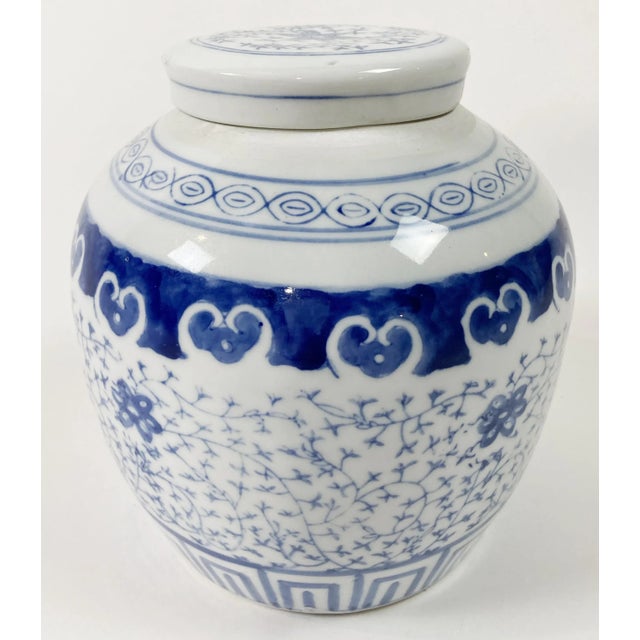 Vintage lidded blue and white Asian ginger jar with lotus root detail to base and lid. Minor age wear. No chips or cracks.