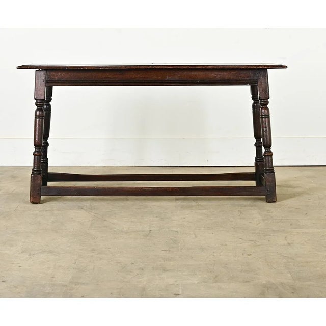 An exceptional solid oak "joint stool" made in England dating to the 1700s, elongated to bench proportions for seating, a...