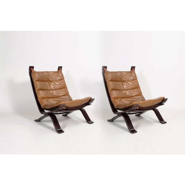 A pair of original Focus sling-type lounge chairs, manufactured by Bramin Møbler in the 1970s. The chairs contain cognac...