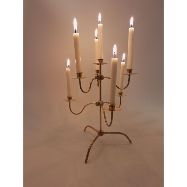 Elegant mid-century modern brass candelabra with adjustable arms that can be raised or lowered to create different...