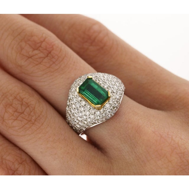 This ring is a 1.25 carat moderate oil Zambian emerald, adorned with 118 round cut diamonds that total 1.37 CTTW. The...
