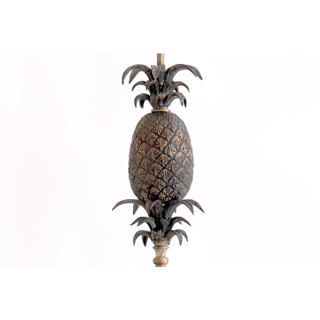 This elegant 20th-century metal table lamp features a striking pineapple motif symbolizing warmth, hospitality, and...