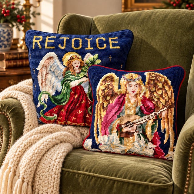 A pair of vintage Christmas needlepoint pillows featuring angels against deep navy blue backgrounds. One depicts an angel...