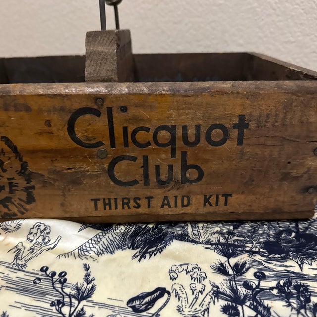 An authentic antique Clicquot Club ginger ale wooden shipping crate featuring the iconic “Old Eskimo” trademark graphic,...