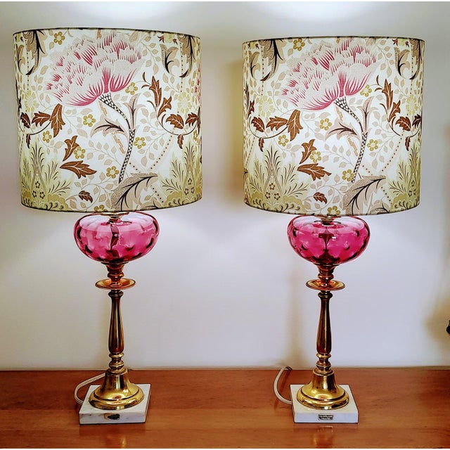 Beautiful pair of vintage lamps featuring cranberry glass globes, brass detailing and a fine marble base made in Italy....