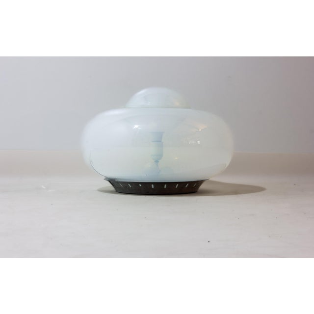 A soft, rounded Murano lamp in opaline glass with a subtle blue tint when off. The double-layered shape creates a...