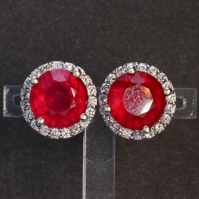 Here is a pair of 14k White Gold Stud Earrings with Two ~5.0ct. Round Lab Ruby Center Stones & Multiple ~0.4ct. G/I1 White...