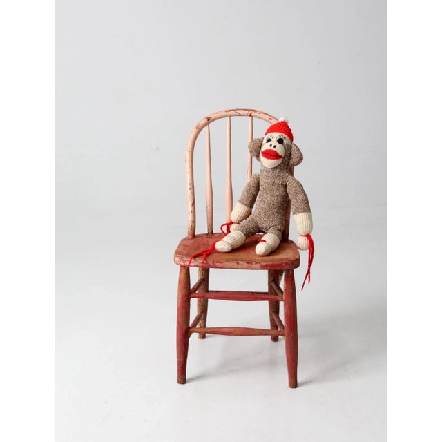 Early 20th century vintage spindle back children's chair painted with faded red and chipped pink paint. Perfectly aged for...
