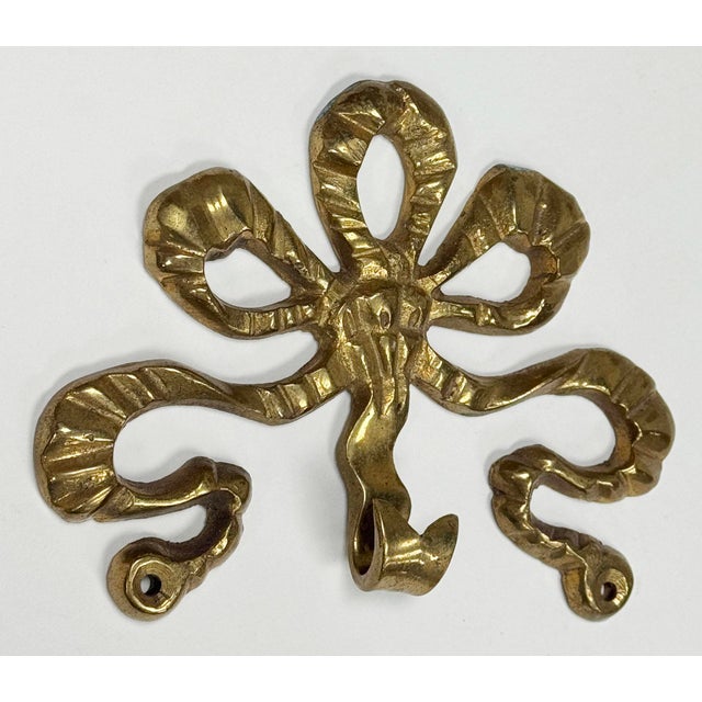 Vintage large brass ribbon bow motif wall hook. Single hook for hanging. Two holes to secure to wall. Lovely patina.