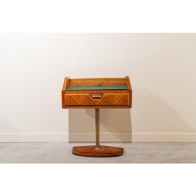 Set of Italian bedside tables from the 1950s in walnut and glass. They consist of a rectangular body supported by a...
