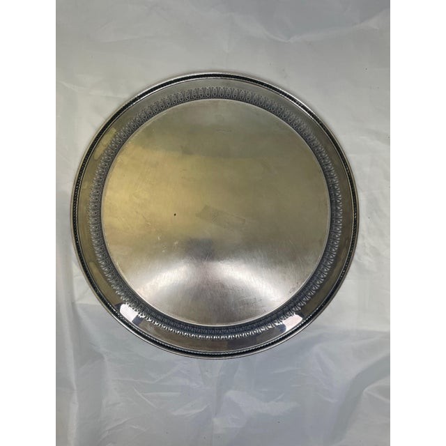 Elevate your serving game with this daring 15-inch W. M. Rogers Large Silver Plate Tray. Its bold size and gleaming finish...
