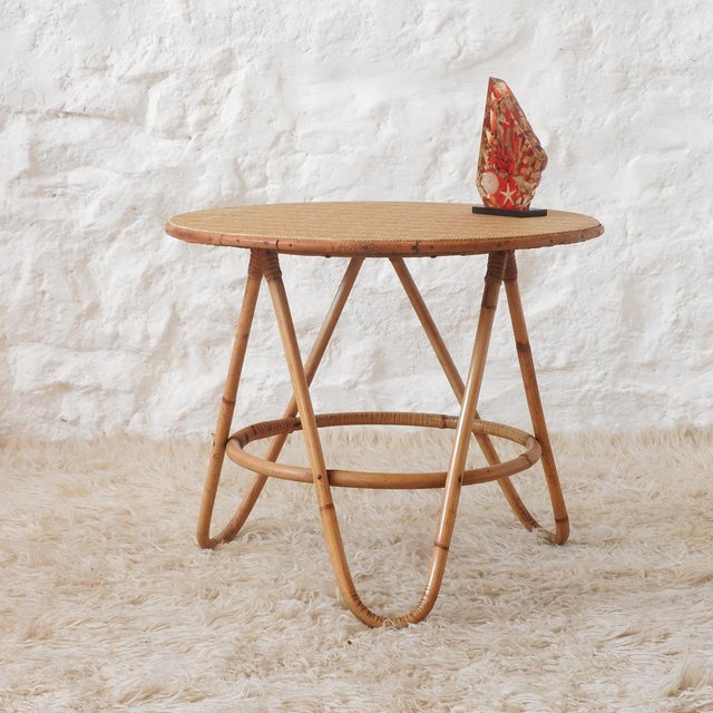 Vintage round coffee table with three curved legs. The legs are bamboo, and the circular tabletop is made of particleboard...