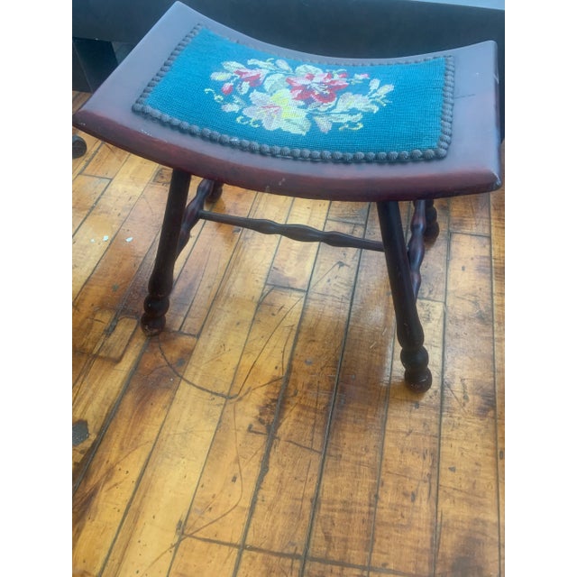 Mahogany bench, with floral design needlepoint saddle style seat and brass tacks.