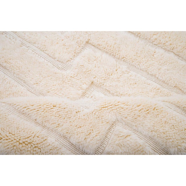 Elegant Moroccan hand-knotted wool rug in Pearled Ivory, featuring a raised geometric pattern. Its timeless design and...
