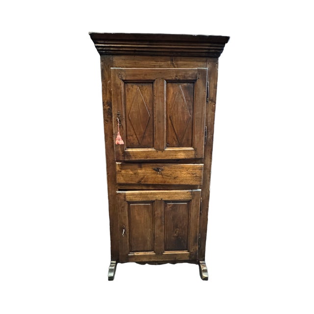 A charming antique French bonnetière dating to the late 18th century, crafted in beautifully aged knotty pine with a warm,...