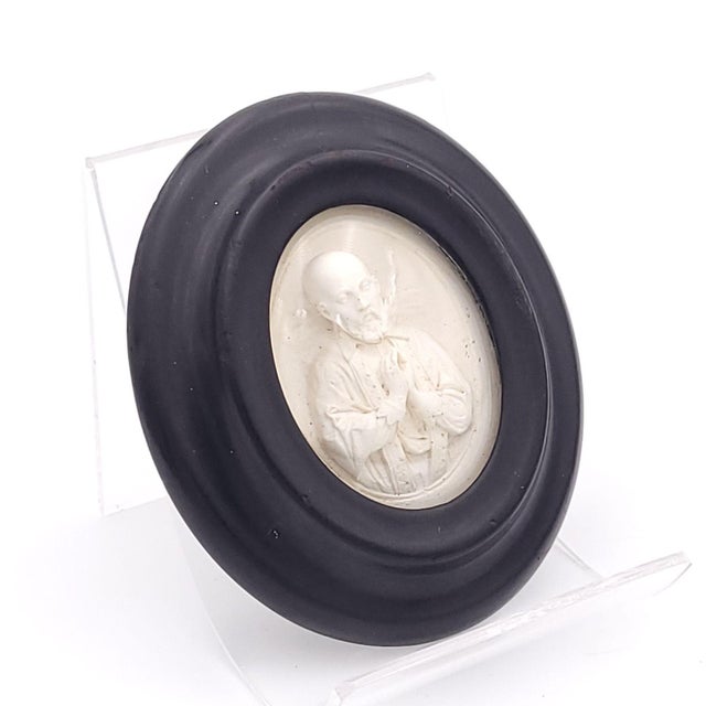 A religious 19th-century souvenir in carved plaster in a black frame with a glass cover; sold at churches. Probably...