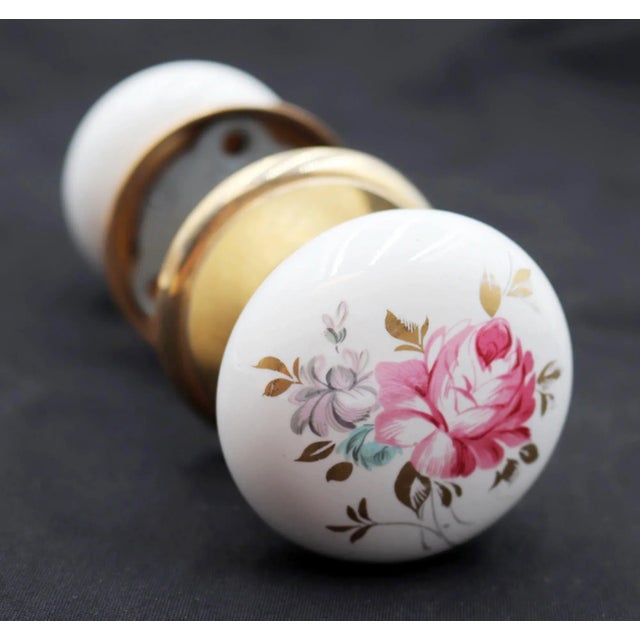 This vintage passage door knob set includes two white ceramic door knobs with a colorful floral motif and two polished...
