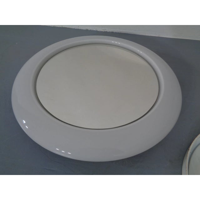 Round, illuminable mirror opal glass from the 1960s. Total diameter 52 cm. Diameter of the mirror 38 cm.