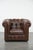 This magnificent brown cowhide Chesterfield club armchair in English style, finished with decorative studs. This...