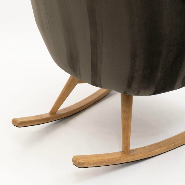 This contemporary gray velvet rocking chair offers a refined blend of comfort and modern style. The smooth, upholstered...