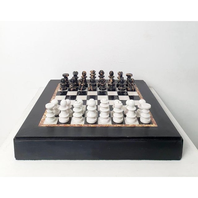 Classic chess board in black and white marble with chess pieces to match in white and black marble as well.