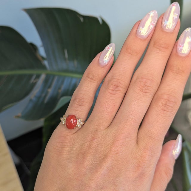 This striking Coral ring features a vibrant 2.3ct 10x8mm Italian coral centerpiece, set in solid 14K gold for a rich and...