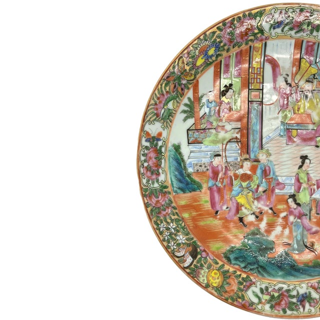 A Canton Famille Rose 12.75-inch charger, the polychrome enameled surface depicting an active palace scene with a...