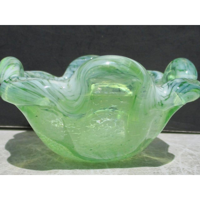 Scalloped bowl with lobed rim of up-down lobes. Speckled pale blue in a bottle green glass. Pontil marks th the bottom....