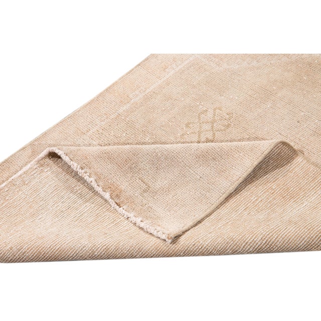 Beautiful vintage runner rug, hand knotted wool with a tan field, ivory accents in a center medallion. This rug measures...