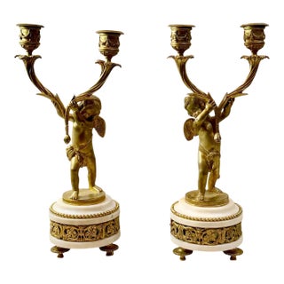French Louis XVI Bronze Doré Candlesticks With Cherubs on Marble Plinths - A Pair For Sale