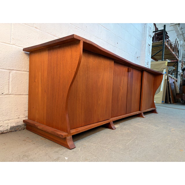 Stunning Mid-Century Modern live-edge walnut sideboard. Crafted from rich, solid walnut, this piece showcases the natural...