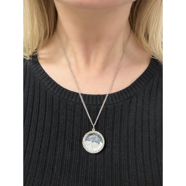 An exquisite Renee Lewis necklace showcasing a shaker pendant with faceted rock crystal compartment holding a collection...
