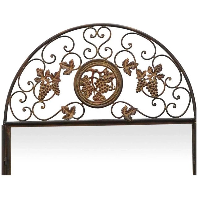 Antiqued metal wall mirror comprising of two open work hinged metal doors with a latch partially concealing the glass,...