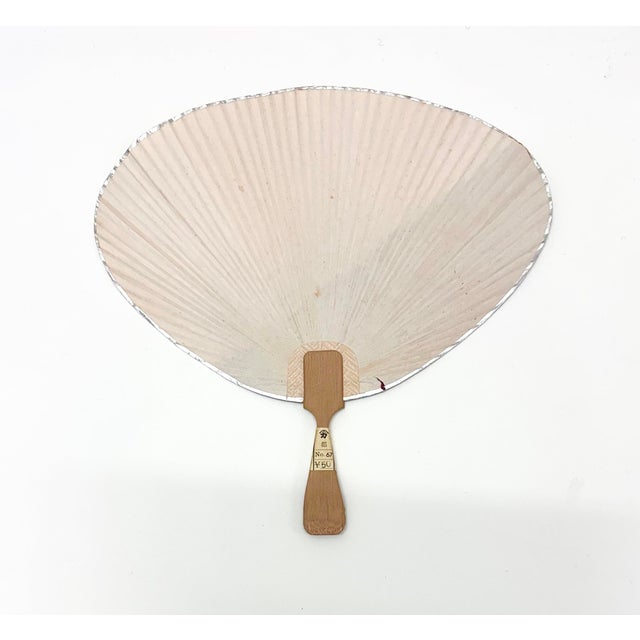 Mid-century Japanese rigid fan featuring a maroon and natural diagonal layout with decorative inset detail. A refined...