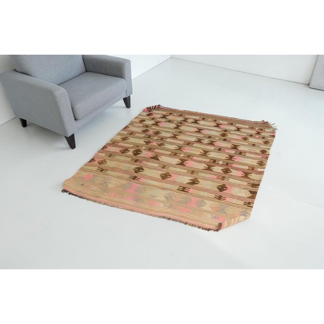 This is a vintage Turkish Oushak rug from the Mid 20th Century. The piece was hand-knotted.