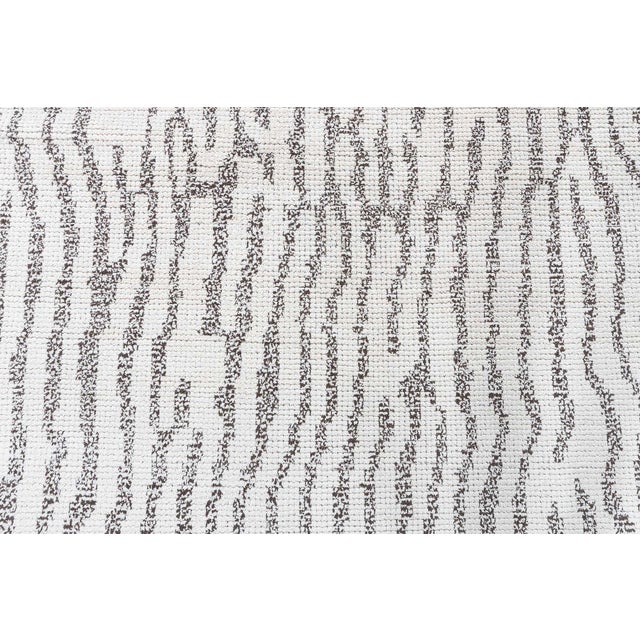 This contemporary Moroccan rug showcases a beautifully organic, textural design in a palette of soft ivory and rich cocoa...