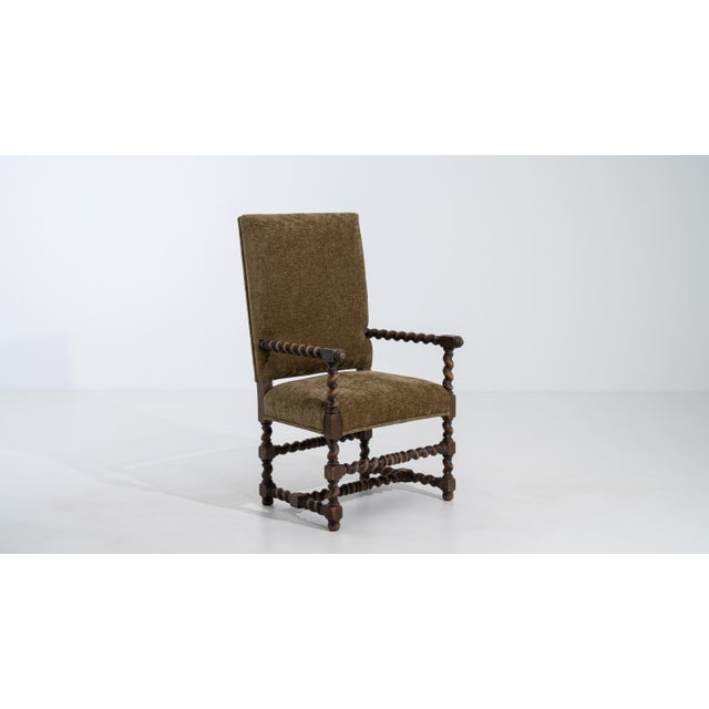 A 19th century throne chair designed in the Louis XIII style, featuring a structured wooden frame with a high back. The...