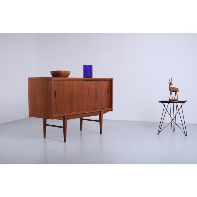 Charming original 1950s sideboard in warm teak veneer, compact size of 104 cm wide. The clean lines are typical of the...