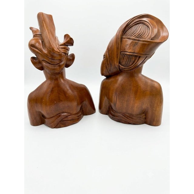 Offered is a striking, exceptionally detailed pair of mid-century hand-carved wooden busts depicting a traditional...