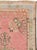 A vintage Turkish Oushak throw rug. The rose-grey semi-open field displays a sand medallion with small stylized flower...