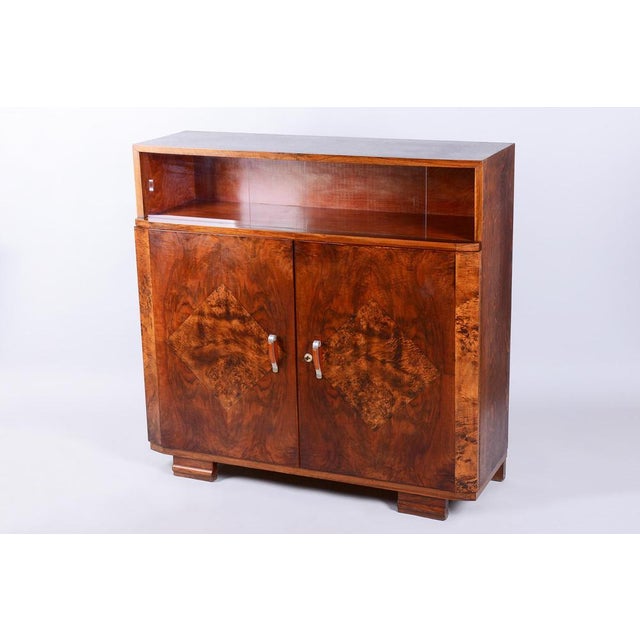 This luxurious commode, serving as a stylish cabinet with a showcase, is an authentic example of the refined Art Deco...