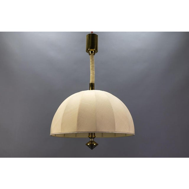 Beautiful adjustable-height three-light brass pendant lamp with a fabric lampshade, Germany, circa 1980. Made in the...