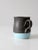 This is a handcrafted studio pottery mug by Nicky Ross of NStar Studio, dated 2012. The form is finished with a charcoal...