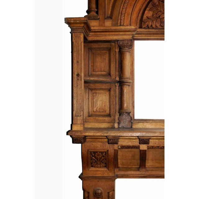 Antique Romanesque Revival style carved oak fireplace mantel and portal form overmantel with display shelves and mirror...