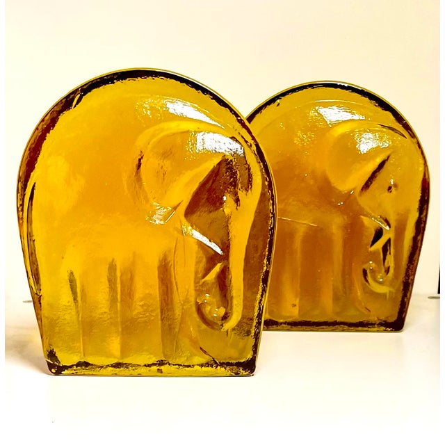 Joel Myers designed these elephant bookends for Blenko in 1969. Product/Catalog #699A, Shown here in Amber, these are mold...