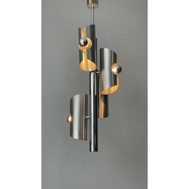 A sleek silver lamp featuring four elegant silver-top bulbs, offering a minimalist yet sophisticated design that...