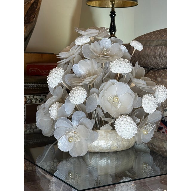 Tarpon scales and sea urchin shells all place together to make a wonderful and highly decorative floral arrangement .