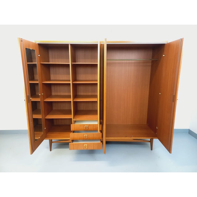 Vintage Scandinavian wardrobe from the 1960s, made of teak, with striking, airy, splayed legs. Ample storage: 4 doors with...