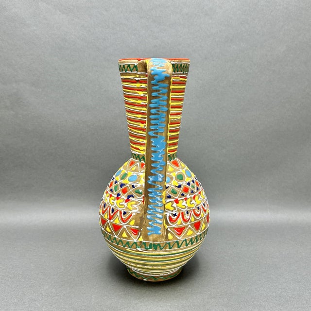Vintage Mid Century Modern studio art pottery pitcher. The interior is glazed turquoise. The exterior is decorated with...