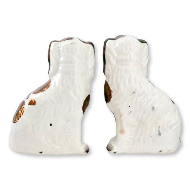 Mid 19th century pair of English Staffordshire dogs decorated with copper lustre accents and hand-painted detailing. The...